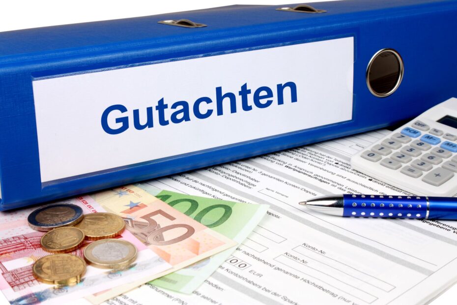 Ordner beschriftet mit 'Gutachten' neben Geld und Rechner