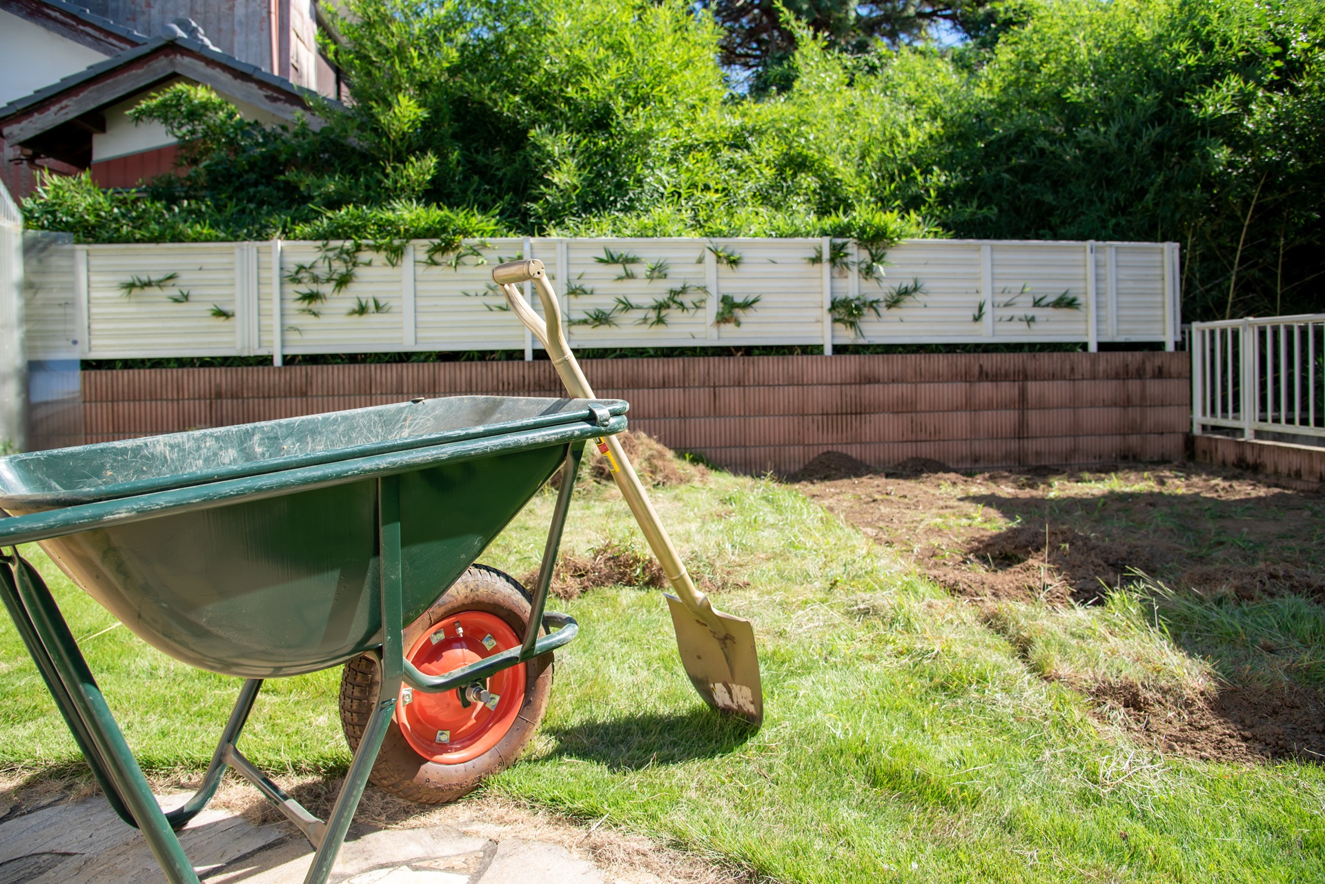 Schubkarre und Spaten im Garten bei Erdarbeiten | Sonnensegel nach Maß